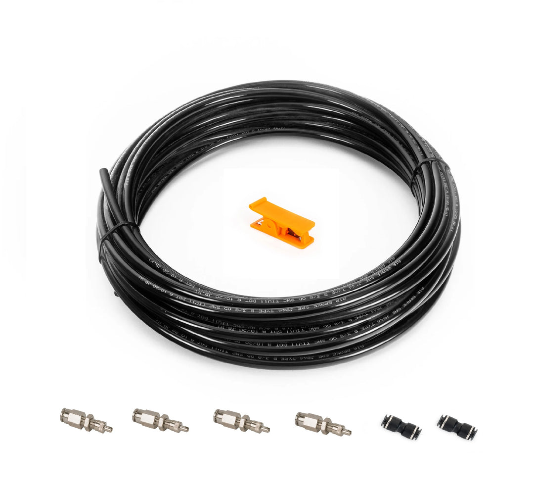A coiled black cable or hose with a small orange connector piece and several small metal and black fittings arranged below on a white background.