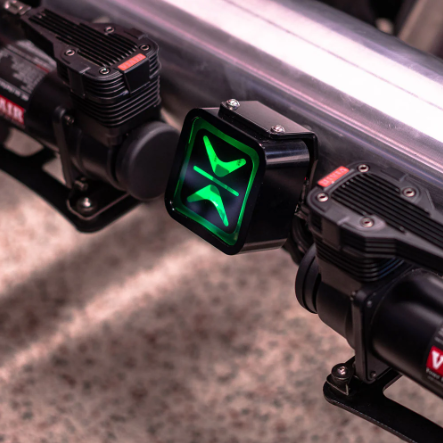 Close-up of a vehicle light bar with a green logo on a blurred background
